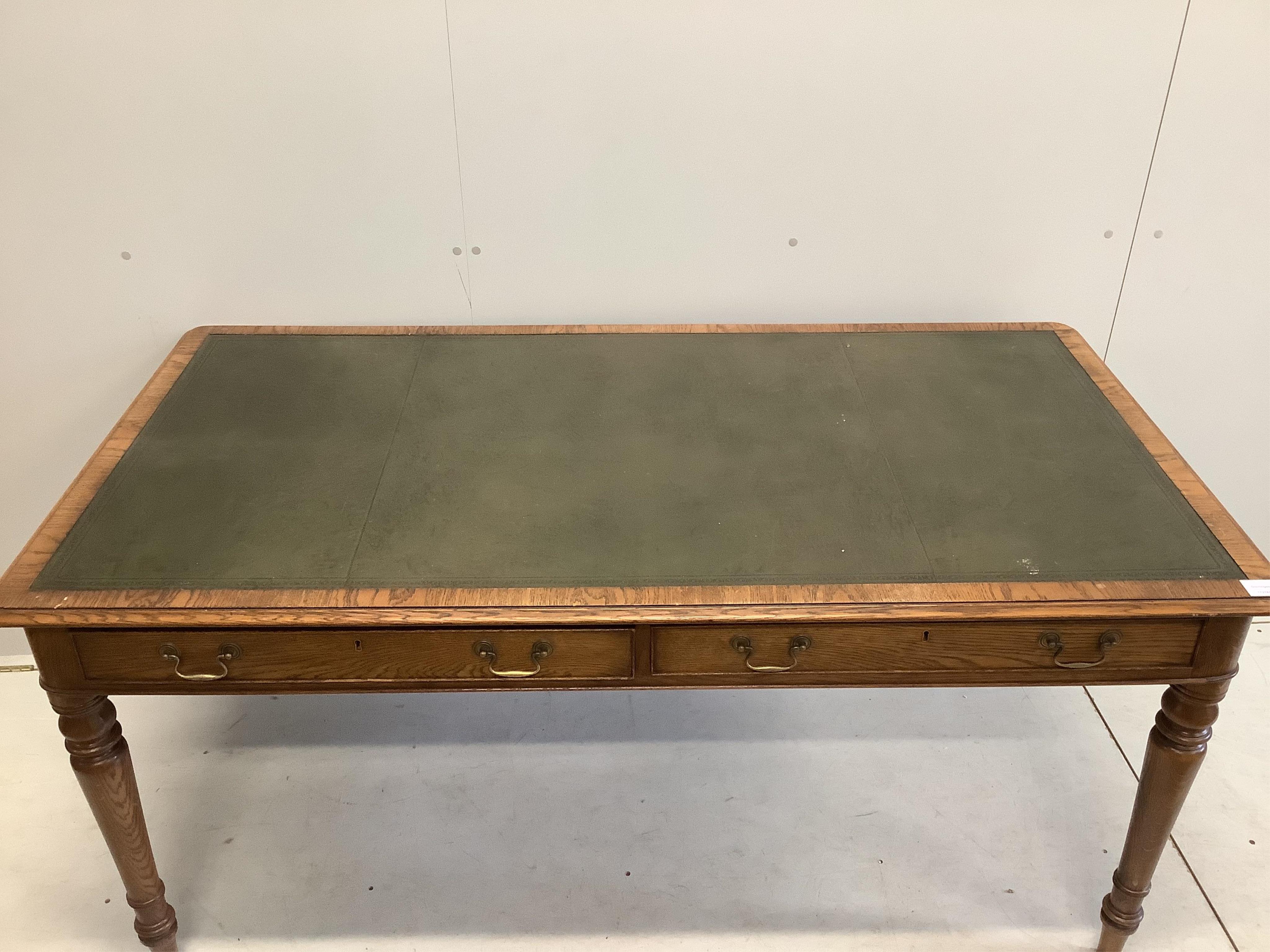 A reproduction Victorian style oak two drawer writing table, width 160cm, depth 84cm, height 76cm. Condition - good